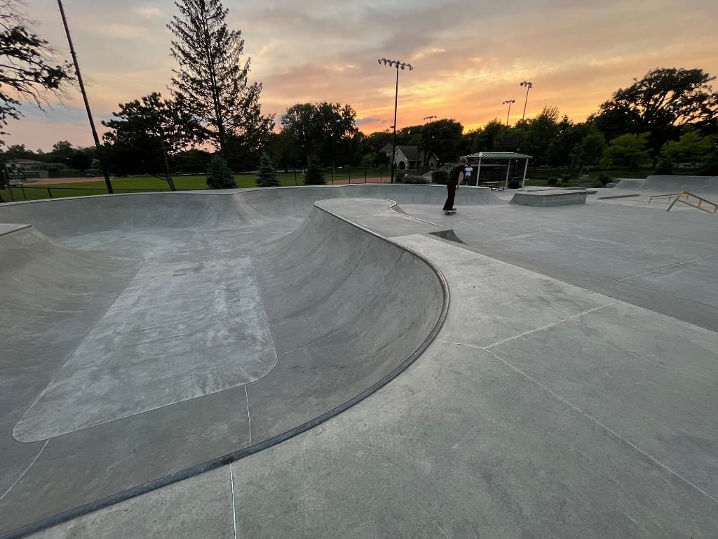 Concrete skatepark bowls and transitions at golden hour